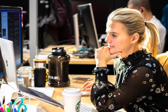 A woman working at her laptop in an office setting